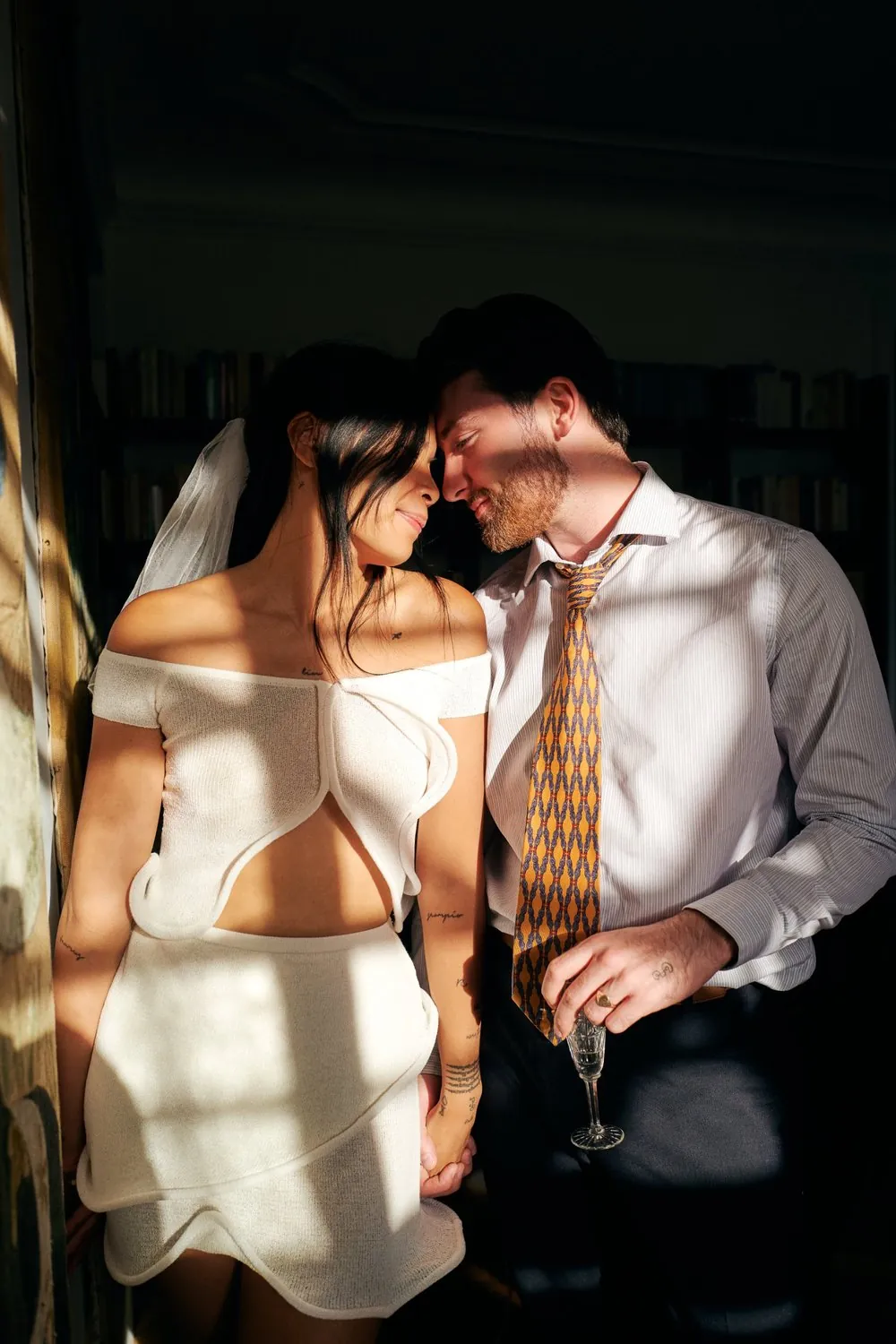Couple front contre front dans la lumière, robe courte et voile